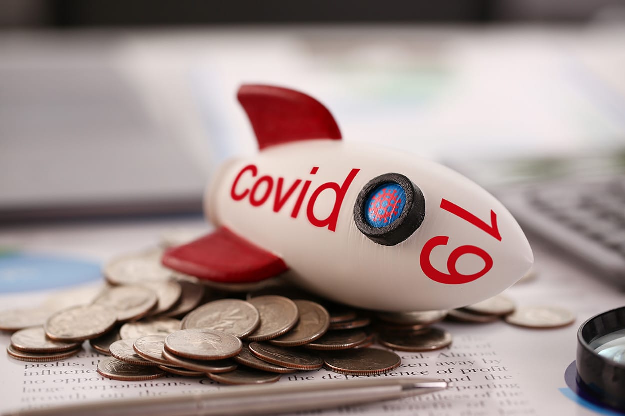 covid 19 submarine on top of coins to represent financial hardship