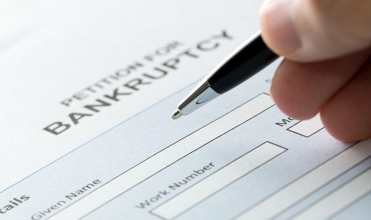 picture of a hand filling out bankruptcy form